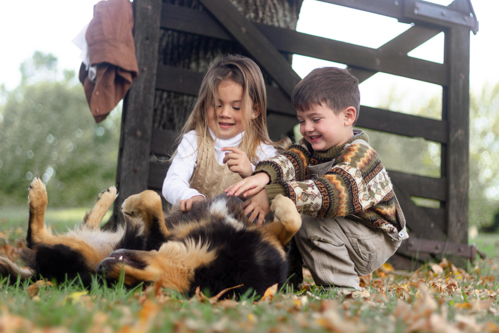 two kids play with dog